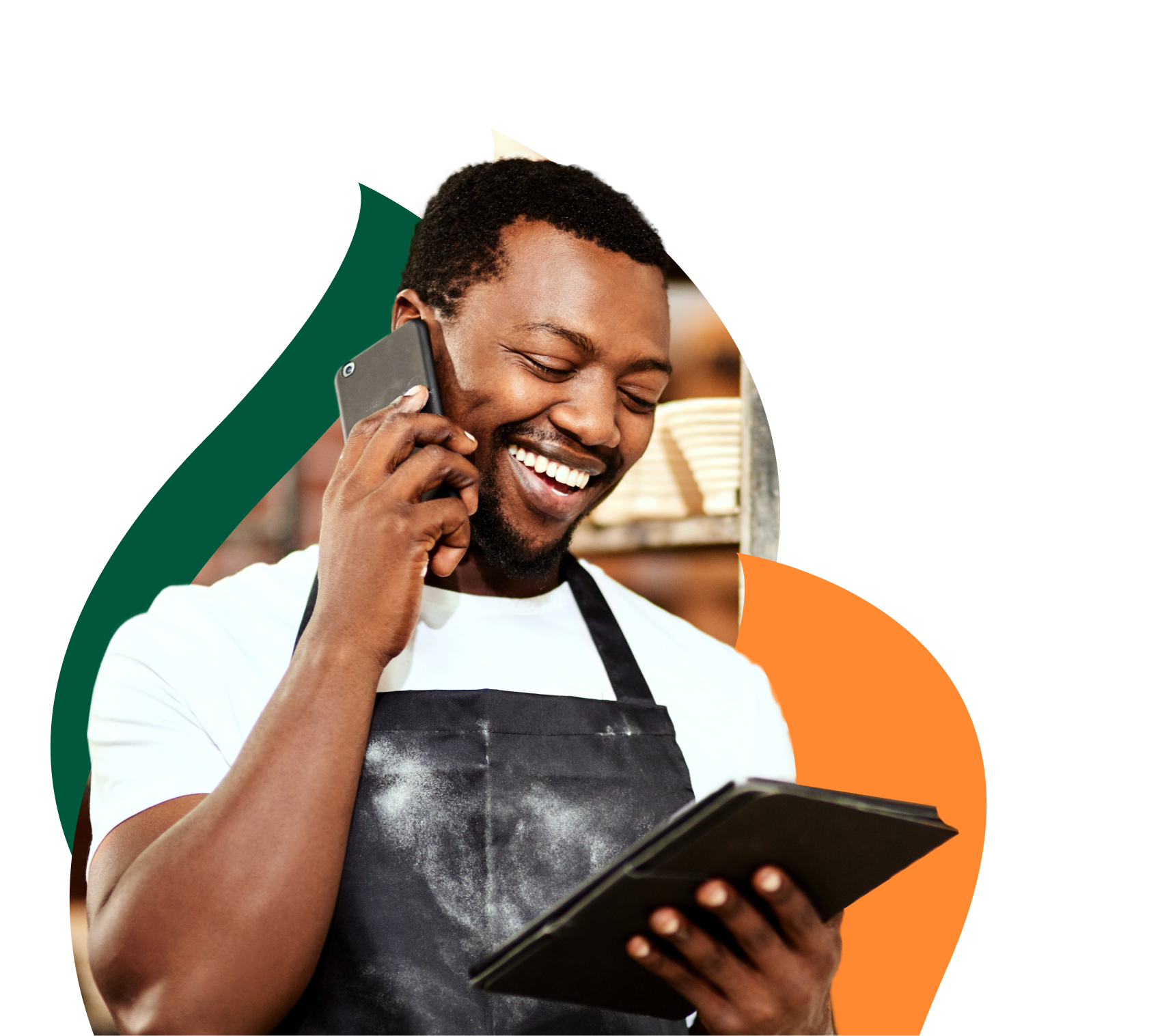 Empresário sorridente falando ao celular enquanto segura um tablet.